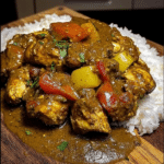 Bowl of Authentic Jamaican Curry Chicken with colorful vegetables and spices
