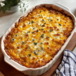 Delicious breakfast hashbrown casserole topped with melted cheese and fresh herbs